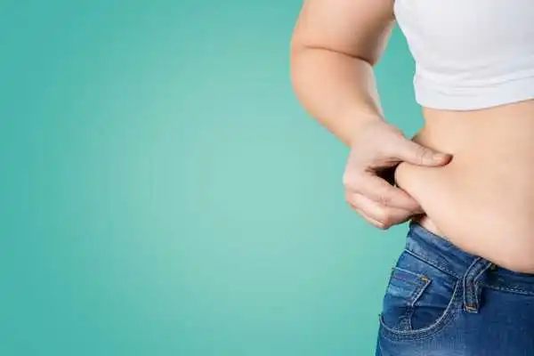 Image of woman pinching her love handles to show weight gain Isle of Isla